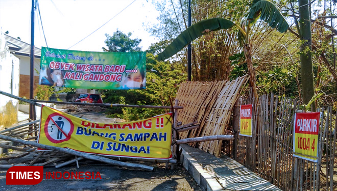 Sejumlah banner dipasang warga di lokasi jalan longsor yang berada di kawasan sungai Gandong Magetan. (FOTO: M Kilat Adinugroho/TIMES Indonesia) 