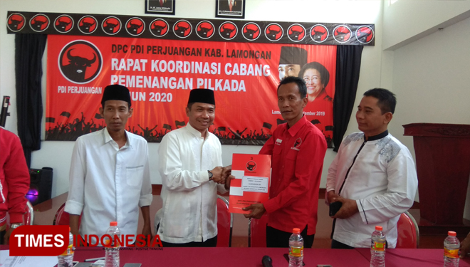 Ketua Partai NasDem Lamongan, Kaharudin (dua dari kiri), mengambil formulir pendaftaran di kantor DPC PDI Perjuangan Lamongan, Jum'at (13/9/2019). (FOTO: MFA Rohmatuillah/TIMES Indonesia)