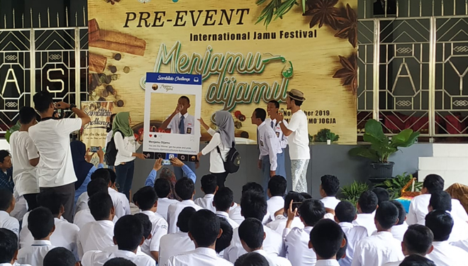 Siswa SMA Negeri 2 Bantul mengacungkan gelas berisi jamu kemudian minum secara bersama-sama. (FOTO: Istimewa/TIMES Indonesia)