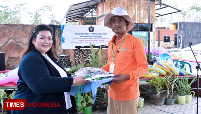 Ketua pelaksana Doktor Mengabdi 2019 menyerahkan alat promosi dsn Corporate Identity kepada Ketua Bumdes Umbul Damar, Senin (23/9/2019).(Foto: Sholeh/ TIMES Indonesia)