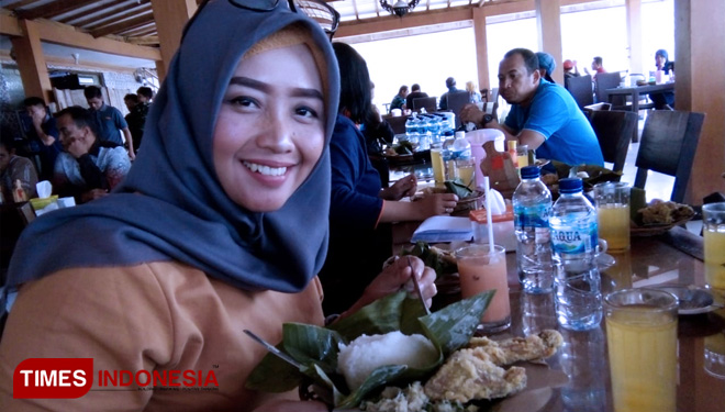 Lia Eka menikmati nasi menok, kuliner khas Magetan di Mbah Djoe Resort & Resto. (FOTO: Miftakhul Arif/Times Indonesia)