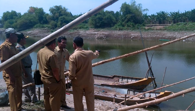 Petugas dari Dinas Pariwisata dan Kebudayaan (Disparbud) Lamongan melihat lokasi penemuan perahu di dasar Bengawan Solo, Selasa (8/10/2019). (FOTO: Istimewa)