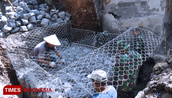 Keceriaan Satgas TMMD Bersama Warga Memasang Kawat Bronjong. (FOTO: AJP/TIMES Indonesia)