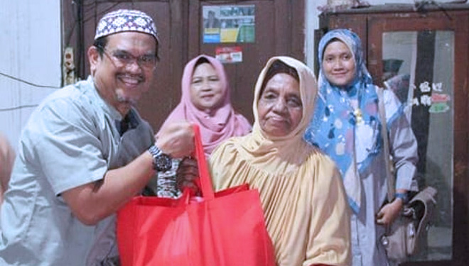 Kepala Dinas Perkim Kota Madiun, Soeko Dwi Handiarto menyerahkan bantuan paket sembako kepada waega. (FOTO: Istimewa)