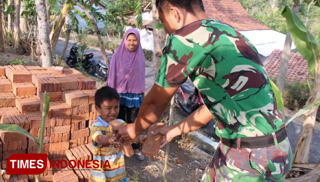 Bagas Bantu Satgas TMMD Angkut Batu Bata. (FOTO: AJP/TIMES Indonesia)