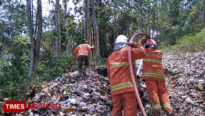 Petugas gabungan PMK dan BPBD Kota Batu berusaha keras memadamkan api yang membakar TPS di Dusun Gondang. (Pusdalops BPBD Kota Batu/TIMES Indonesia) 