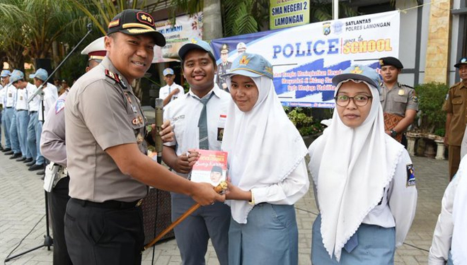 Kapolres Lamongan, AKBP Feby DP Hutagalung memberikan sebuah buku kepada siswa di salah satu sekolah yang dikunjungi, Rabu (16/10/2019). (FOTO: Istimewa)