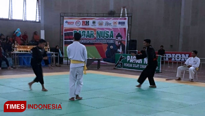 Dua atlet Pagar Nusa sedang adu skil di atas arena dalam kejuaraan pencak silat di GOR Pelita (FOTO: Moh Bahri/TIMES Indonesia). 
