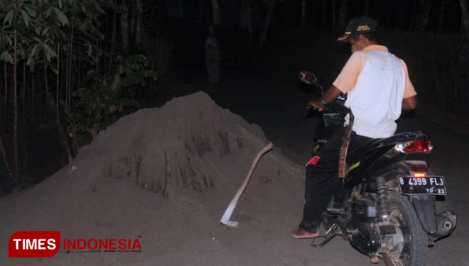 Kadus Radin, amankan cangkul yang masih tergeletak di pinggir jalan. (FOTO: AJP/TIMES Indonesia)