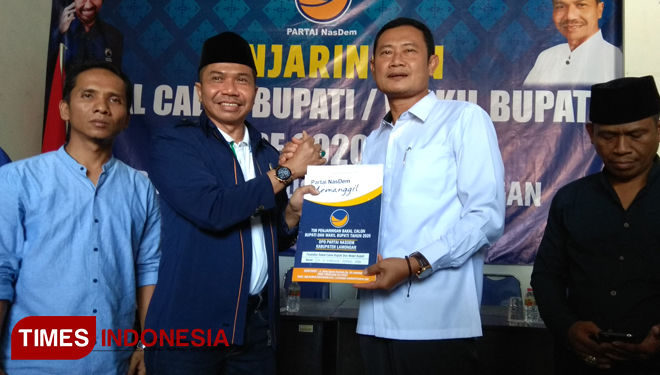 Yuhronur Efendi (putih) menyerahkan formulir pendaftaran Bacabup Lamongan kepada Ketua DPD NasDem Lamongan, Kaharudin, Rabu (23/10/2019). (FOTO: MFA Rohmatillah/TIMES Indonesia)