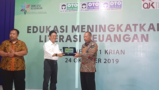 Nugroho Triko Pramono selaku Direktur & Corporate Secretary OTO Group saat menyerahkan CSR ke Kepala Sekolah SMA Negeri 1 Krian, Sidoarjo