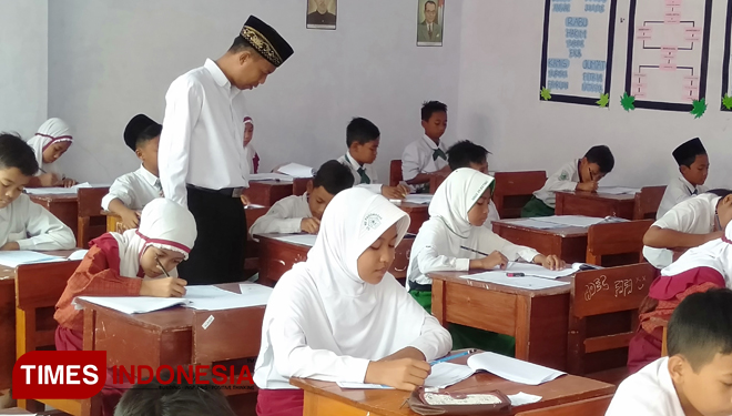 Peserta uji coba ujian di MTs Al Qodiri IV Jember fokus mengerjakan soal ujian, Selasa (5/11/2019). (Foto: Dody Bayu Prasetyo/TIMES Indonesia)