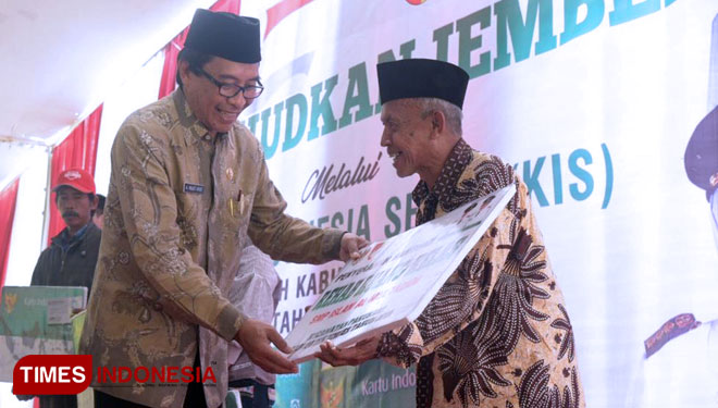 Wakil Bupati Jember KH Abdul Muqit Arief menyerahkan KIS secara simbolis kepada warga di Kecamatan Pakusari, Kamis (7/11/2019). (Foto: Humas Pemkab Jember for TIMES Indonesia)