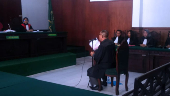Terdakwa Guntual Laremba saat mengikuti sidang memakai toga di Pengadilan Negeri Sidoarjo. (foto: Istimewa)