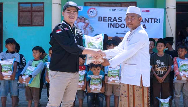 Kepala Cabang ACT Malang Diki Taufik Sidik menyerahkan bantuan beras sebagai bahan pangan para santri kepada Pengasuh Ponpes Kuai Syaiful Razi. (Foto : ACT for TIMES Indonesia)