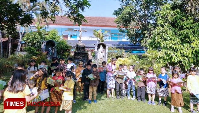 Siswa SDK Santa Maria 2 Malang melakukan kegiatan membaca bersama di luar kelas dalam kegiatan Literasi ku. (foto: SDK Santa Maria 2 Malang). (FOTO: AJP/TIMES Indonesia)
