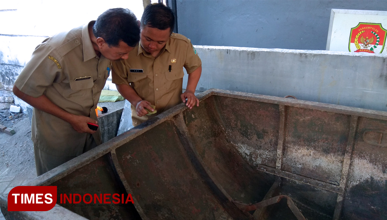 Kepala Disparbud Lamongan, Ismunawan (kiri), melihat tulisan yang berada di ujung badan kapal, Senin (11/11/2019). (FOTO: MFA Rohmatillah/TIMES Indonesia)