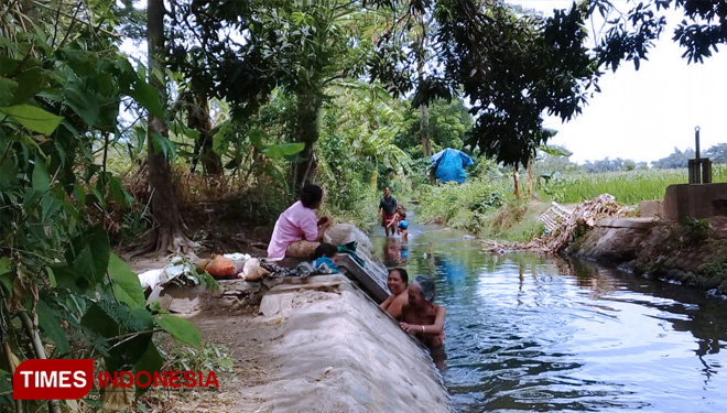 Warga terpaksa harus mandi di sungai, lantaran mesin pompa listrik mati. (FOTO: Andi for TIMES Indonesia)