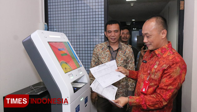 Dirjen Dukcapil Kemendagri Zudan Arif Fakrulloh saat menjajal Anjungan Dukcapil Mandiri (ADM) yang baru di-launching. (FOTO: Hasbullah/TIMES Indonesia).