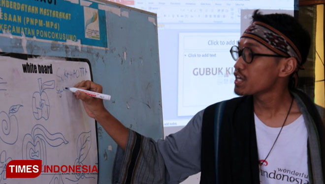 Fikrah Ryanda Saputra bagikan ilmu soal batik kepada Ibu PKK Desa Gubuk Klakah hari ini (18/11/2019). (foto : Widya Amalia/TIMES Indonesia)