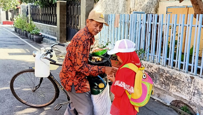 Meriahkan Milad Muhammadiyah ke 107 siswa SD Muhammadiyah 9 Kota Malang membagikan makanan dan minuman bagi pengguna jalan saat pawai taaruf, Senin (18/11/2019)