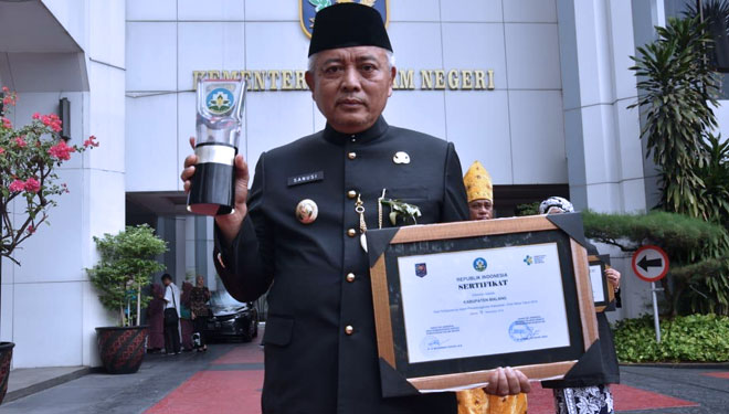 Bupati Malang, Drs HM Sanusi MM saat menunjukkan penghargaan Swasti Saba Wiwerda. (Foto : Humas Pemkab Malang for TIMES Indonesia)