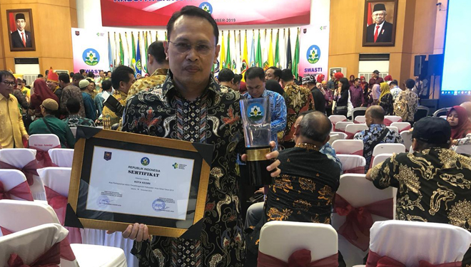 Kepala dinas kesehatan kota Kediri saat terima penghargaan tropi kota sehat