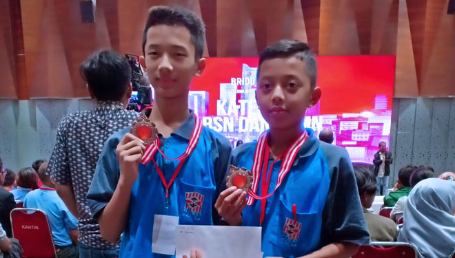 Alif dan Riski menunjukkan medali yang diperolehnya dalam kejuaraan bridge. (Foto: Dok MI Al Huda/TIMES Indonesia)