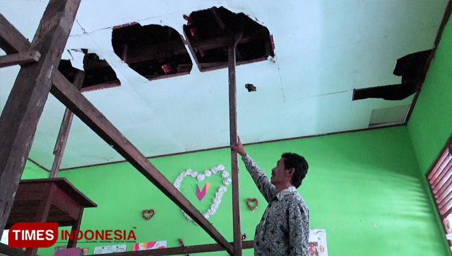 Guru SDN 02 Tawangrejo menunjukkan plafon yang ambrol dan disangga tiang bambu. (FOTO: Ito Wahyu U/TIMES Indonesia)