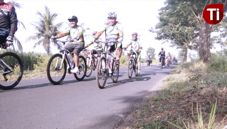 Peserta Fun Bike PG Semboro PTPN XI melintasi rute yang melalui area persawahan, Minggu (1/12/2019). (Foto: Dody Bayu Prasetyo/TIMES INDONESIA)