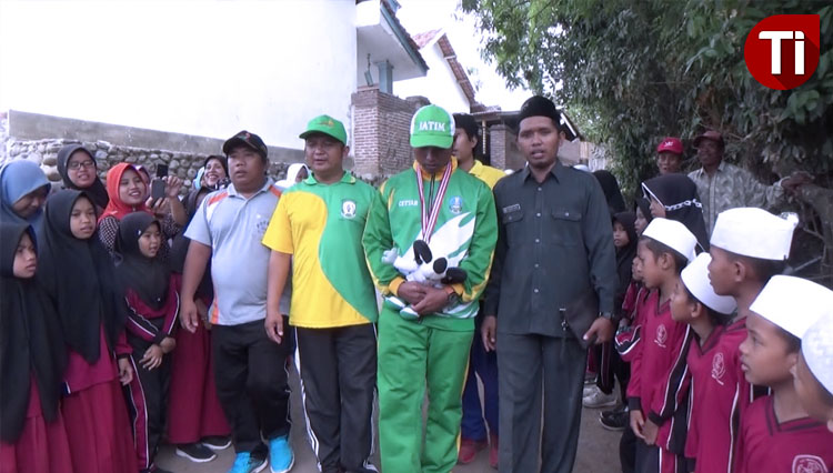 Lukmanul Hakim (tengah, seragam hijau berkalung medali emas) tiba di Ponpes Darut Tauhid.(FOTO: Dicko W/TIMES Indonesia)