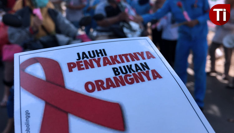 Puluhan perwakilan K3 dari perusahaan membagikan bunga dan stiker HIV/AIDS pada pengendara. (FOTO: Happy/TIMES Indonesia)