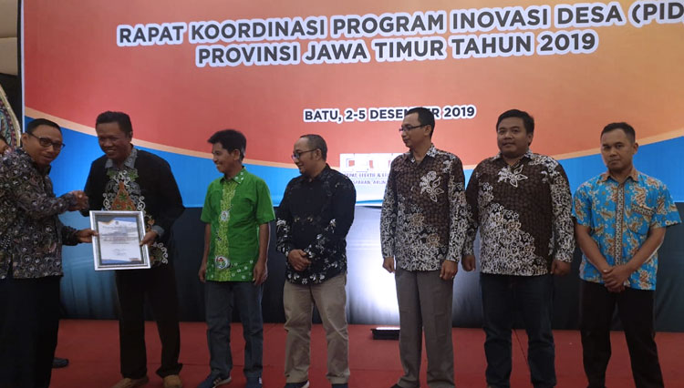 Kepala Desa Suger Lor serta tim pendamping saat menerima penghargaan dari Kepala DPMD Jawa Timur. (FOTO: Istimewa)