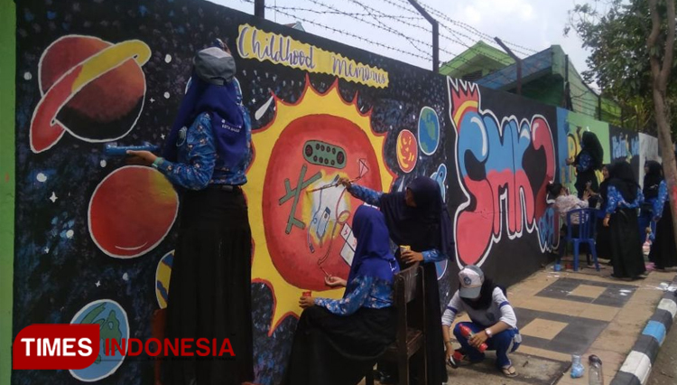 Siswa SMKN 2 Kota Madiun melukis mural di tembok sisi luar sekolahnya. (Foto: Pamula Yohar C/TIMES Indonesia)