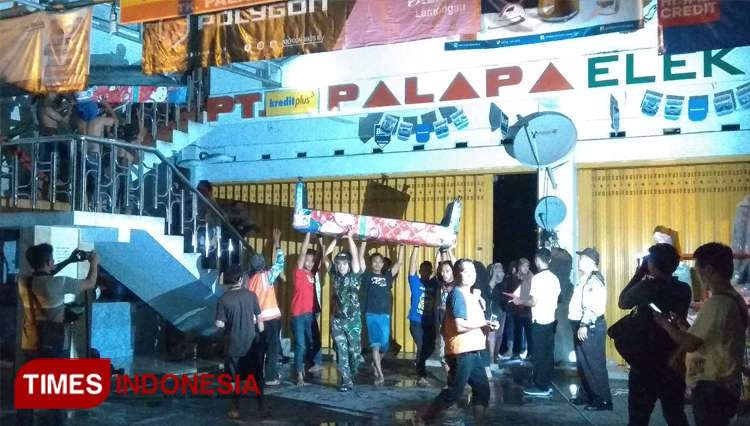 Para karyawan toko Palapa Elektronik mengevakuasi berang yang masih bisa diselamatkan, Kamis (12/12/2019). (FOTO: MFA Rohmatillah/ TIMES Indonesia)