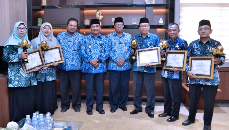 Wabup Qosim saat bersama kepala sekolah penerima piala Adiwiyata. (Foto: Humas Pemkab Gresik/TIMES Indonesia)