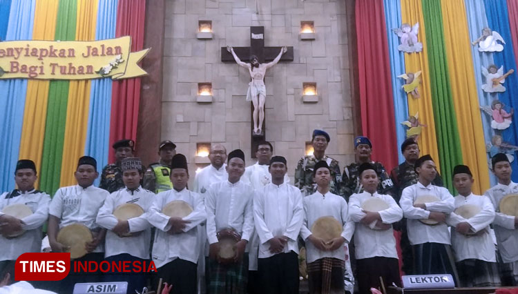 Peserta rebana dan banser berfoto bersama dengan Pastor Kepala Paroki Gereja Katolik Mater Dei Kota Madiun Joko Sulistiyo. (foto: Pamula Yohar C/TIMES Indonesia)