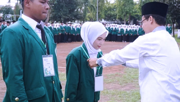 Wakil Rektor IAIN Tulungagung, Abdul Aziz saat mengalungkan tanda peserta KKN 2020, (FOTO: Aam/beritabaru.co)