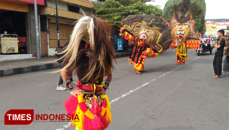 Lurah Sisir, Sasongko Fitra Adhitama SIP MH saat memecah buah kelapa saat Selamatan Desa. (foto: Muhammad Dhani Rahman/TIMES Indonesia) 