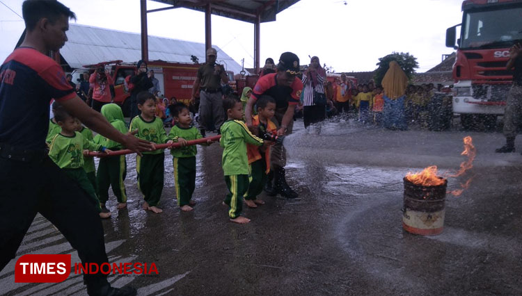 Anak-anak dari KB Al Islam Banjarsari Kabupaten Madiun saat ikuti kegiatan memadamkan api dengan didampingi oleh personel Pemadam Kebakaran. (foto: Pamula Yohar C/ TIMES Indonesia).