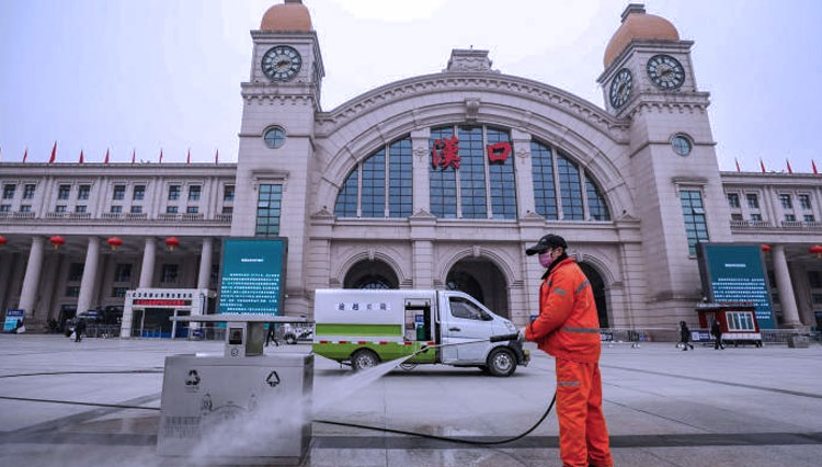 Pekerja membersihkan jalan di depan Stasiun Hankou yang ditutup saat Kota Wuhan diisolasi, di Provinsi Hubei, Tiongkok, Kamis (23/1/2020). (China Daily via REUTERS)