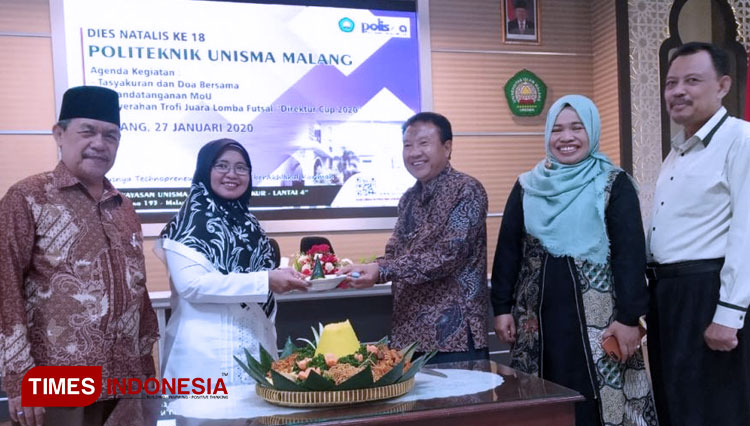 Direktur Polisma Ana Nuril A, S.T., M.T menerima potongan tumpeng dari Prof. Dr. H. Yaqub Cikusin,  M.Si. (FOTO: ajp.TIMES Indonesia)