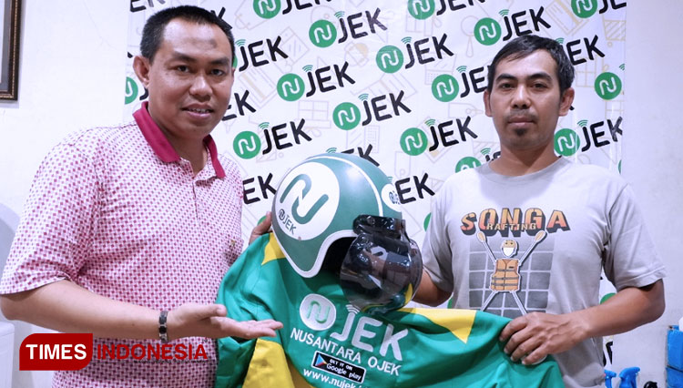 Kepala NUJEK Cabang Malang, Chairul Jamil (kiri) menunjukkan jaket dan helm NUJEK. (FOTO: Naufal Ardiansyah/TIMES Indonesia)