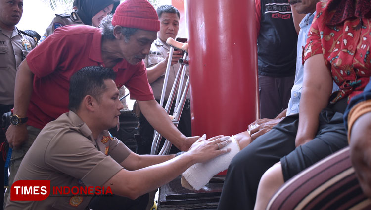 Kapolres Blitar AKBP Budi Hermanto melakukan pengukuran kaki kepada delapan penyandang disabilitas, Kamis (6/2/2020). (Foto: Sholeh/TIMES Indonesia)