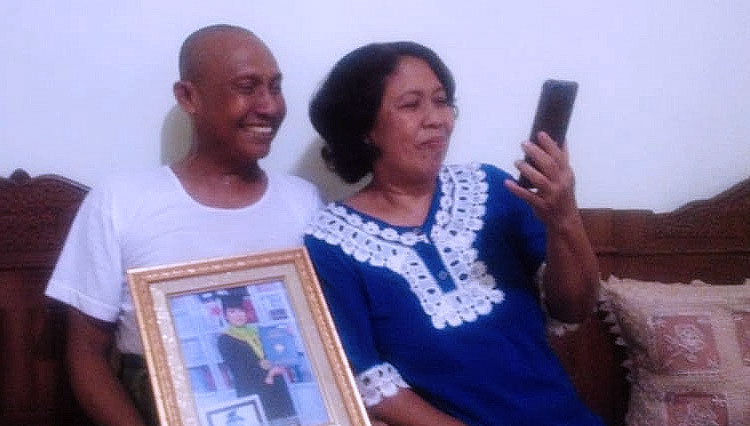 Mariana bersama sang suami, berkomunikasi melalui video call dengan putrinya, Ayu Winda yang sedang menjalani observasi di Natuna. (FOTO: Istimewa)