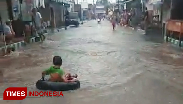 Tangkapan layar video bocah-bocah bermain ban diatas banjir jalanan. (FOTO: Andri for TIMES Indonesia)