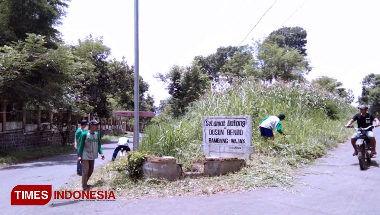 Pembersihan dan renovasi papan batas Desa BambangB: Kegiatan TPQ oleh Kelompok 13. (FOTO: AJP TIMES Indonesia)