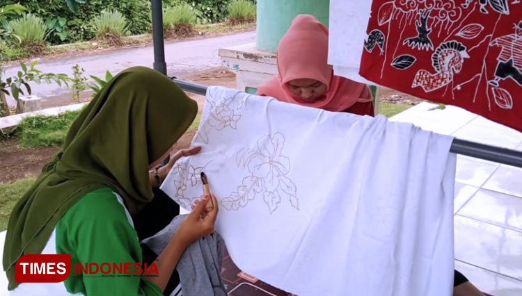 Proses melukis motif batik di kain. (FOTO: AJP TIMES Indonesia)