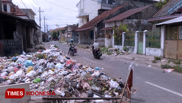 Tumpukan sampah di Jalan Letnan Sunarto, Kelurahan Pangeranan, Kabupaten Bangkalan, menumpuk dan meluber ke jalan raya. (FOTO: Doni Heriyanto/TIMES Indonesia)