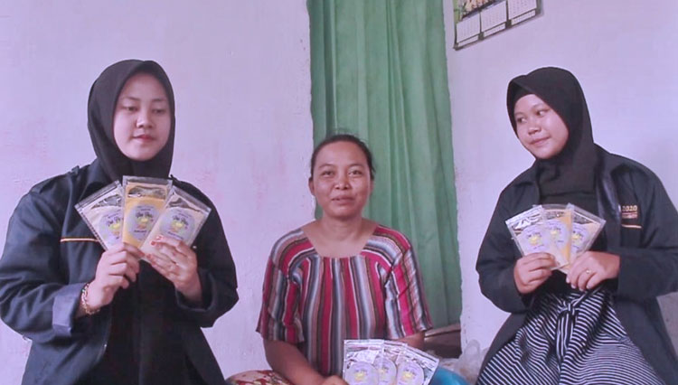 Sulastri (tengah) bersama dua mahasiswi UM Jember memamerkan produk jamu buatannya. (Foto: Humas UM Jember)